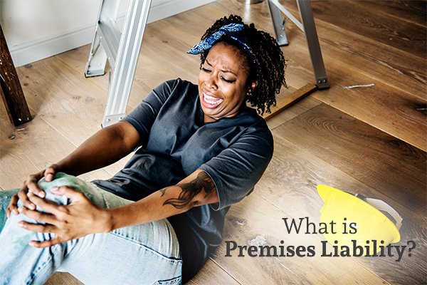 A woman lying on the floor with anguish on her face, clutching her knee, with a ladder in the background, and the words what is premises liability