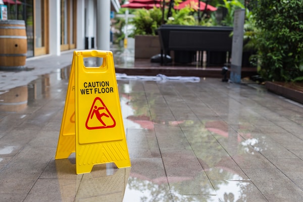 Signo de piso mojado amarillo en el piso de un hotel