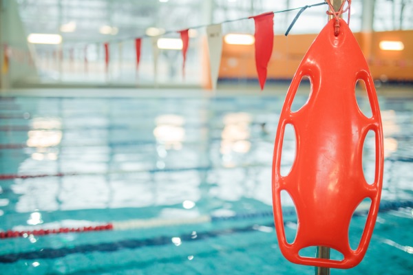 A life preserver in front of a swimming pool. 