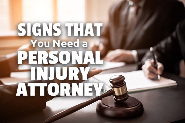 Lawyers meeting with a client with the words, signs that you need a personal injury attorney.