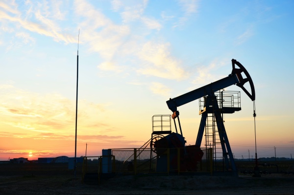 A picture of a sunrise over an oilfield.