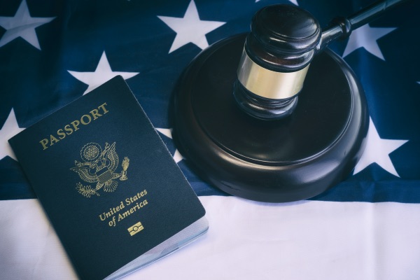 A passport, a gavel, and an American Flag.