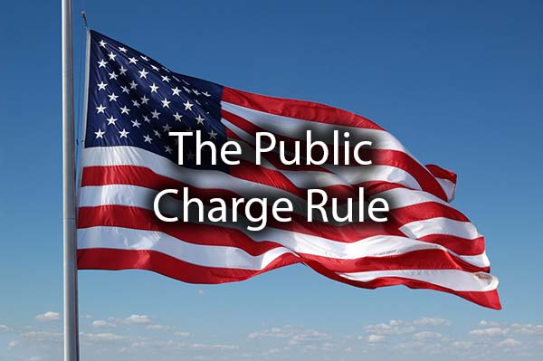 An American Flag with the words, the public charge rule.