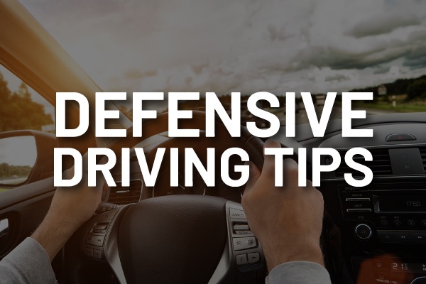 A person driving with the words, "defensive driving tips."