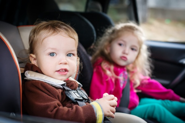 Dos niños en asientos de coche.