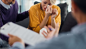 woman wiping eye with tissue