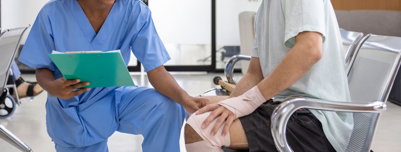 A nurse is checking a patient with a knee injury.