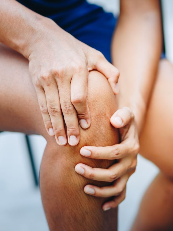 A man holding his knee after a joint injury.