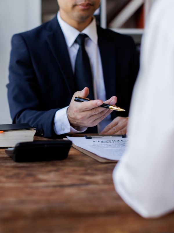 A negligence attorney is talking to a client with a claim form in between them.